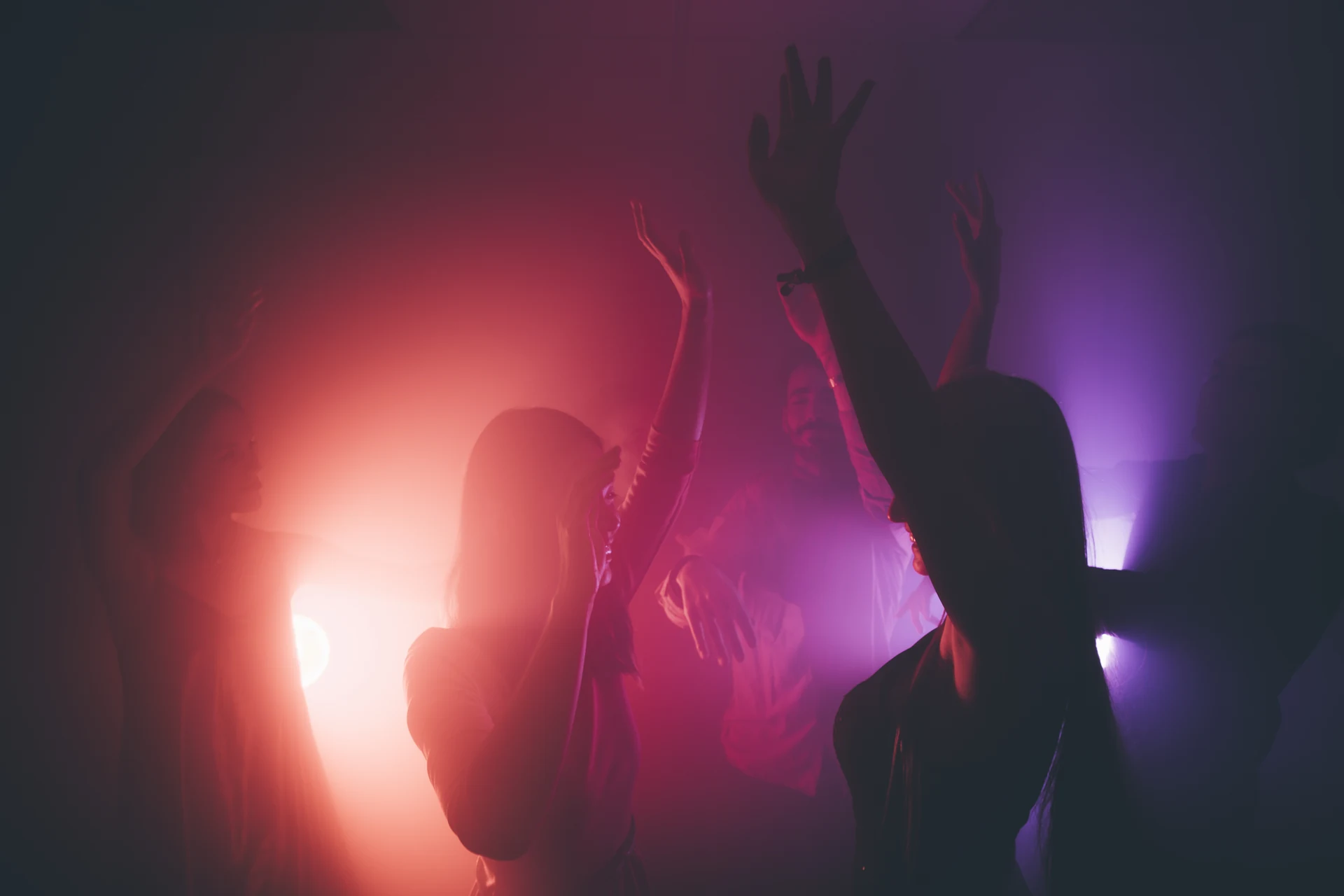 Guests dancing under coloured light at a private party