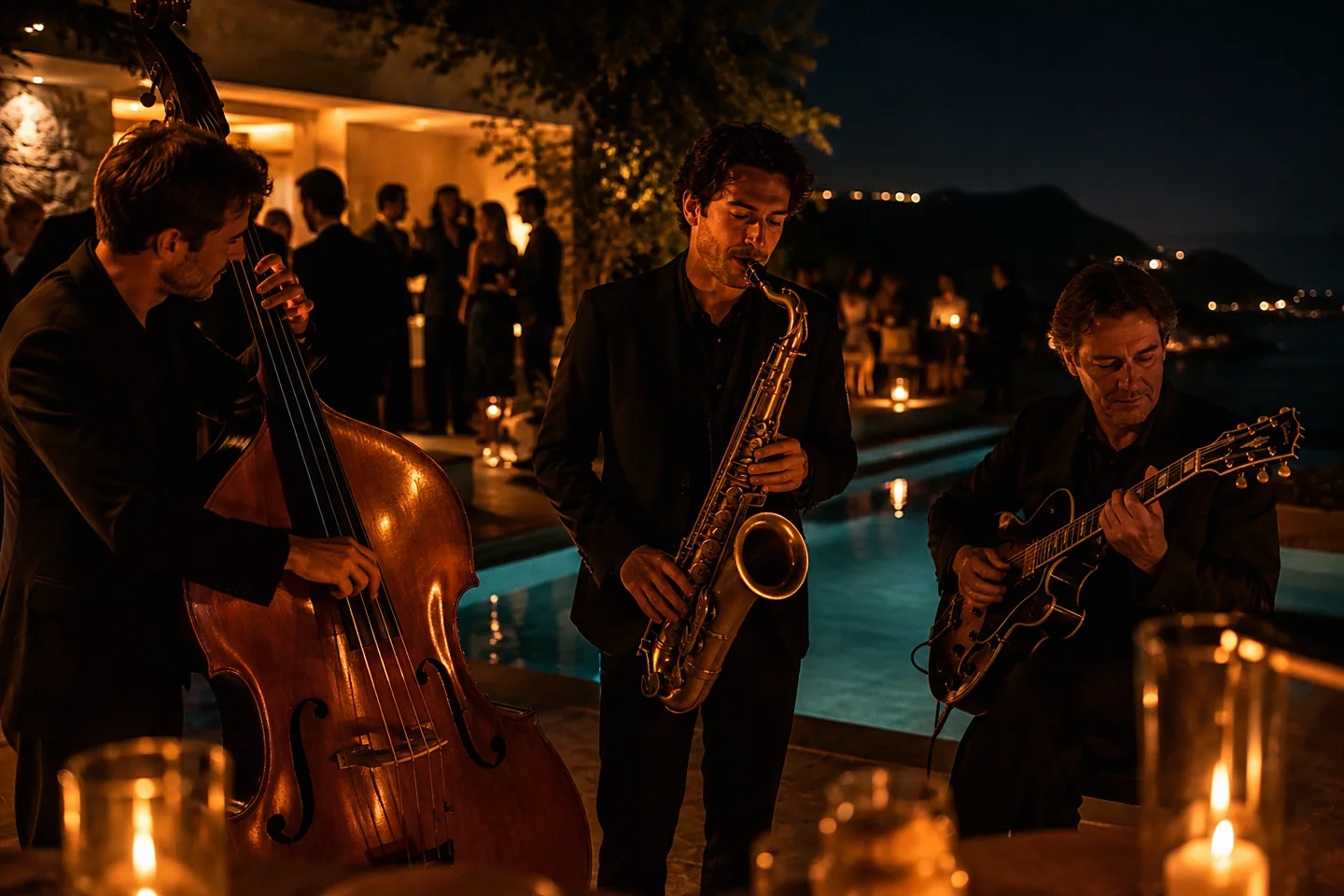 A jazz trio playing beside a lit pool on a villa terrace at night